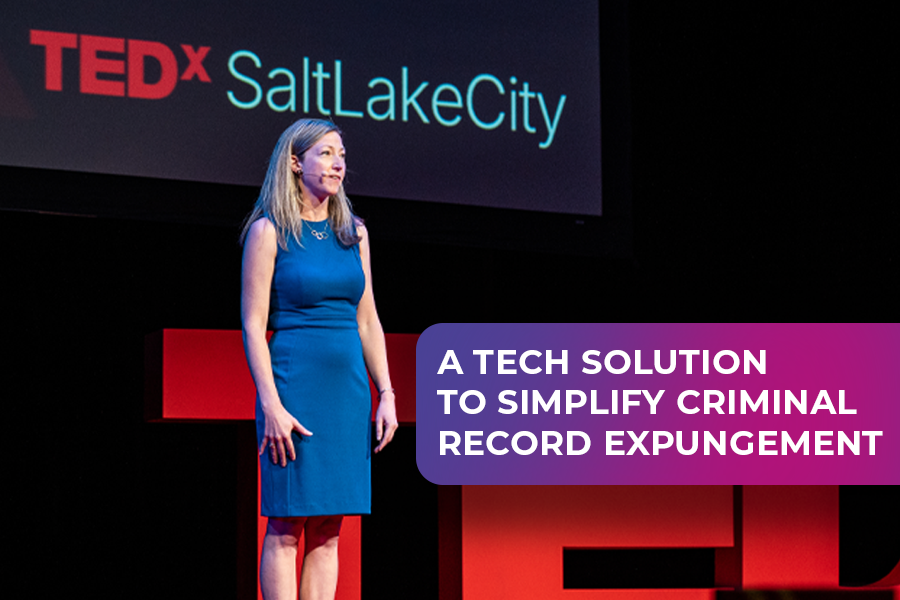 Noella Sudbury, CEO of Rasa, stands on stage at TEDx Salt Lake City, wearing a blue dress, delivering a talk about using technology to simplify criminal record expungement. The backdrop features the TEDx Salt Lake City logo, with the text overlay: "A Tech Solution to Simplify Criminal Record Expungement.